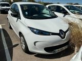 des voitures garées sur un parking, avec des mauvaises herbes qui poussent à l'avant