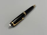 une image représentant un stylo noir et doré posé sur une surface blanche