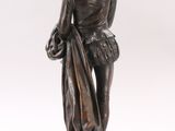 an antique bronze statue of a man holding a bag on a marble base