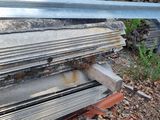 a pile of wood on the ground next to a fence