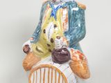 une figurine représentant un homme assis sur une chaise