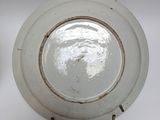 a white plate with a brown rim on a white table