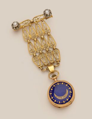 a gold and lapel pin with a blue glass pendant