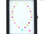 a close up of a picture of a black frame with a pink and yellow bead