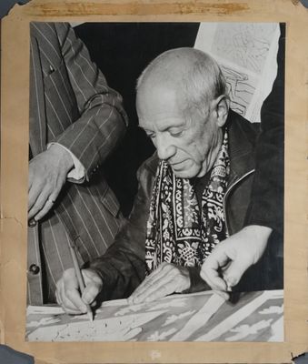 an old black and white photo of a man signing a book