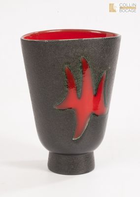 une tasse noire et rouge ornée d'une feuille rouge