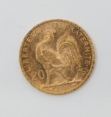 une pièce d'or représentant un coq sur un fond blanc