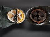 two cups of coffee sitting on a black surface