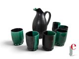 five cups and a pitcher sitting next to each other on a table