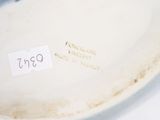 a white bowl with a label on it sitting on a table