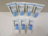 six tubes of toothpaste are lined up on a table
