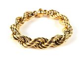 gros plan d'un bracelet en or sur fond blanc