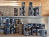many cans of paint sitting on a shelf in a room