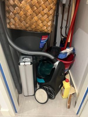 une photo d'une petite pièce avec un aspirateur et un panier