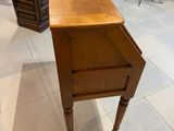 une petite table avec un tiroir, placée au milieu d'une pièce