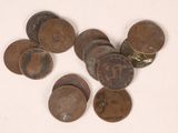 several old coins sitting on top of each other on a white surface