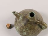 a small brown vase with a small piece of cork in it