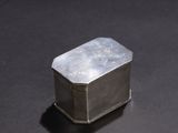 a small silver box sitting on a black surface