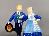 une figurine représentant un homme et une femme tenant un disque vinyle