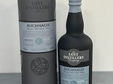 La bouteille d'alcool se trouve à côté de la boîte, sur la table.
