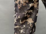 the legs of a person wearing a pair of brown and black camouflage pants