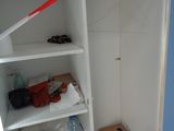 a white closet with shelves and shoes on the floor