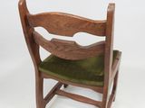 a wooden chair with a green seat on a white background