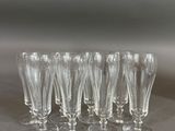 six clear wine glasses are lined up on a table