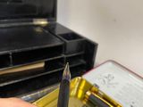 a person holding a pen and a box of pens in their hand