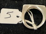 une bague en argent avec une plaquette sur laquelle est inscrit le chiffre 5