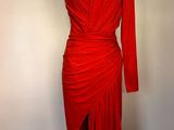 une robe rouge posée sur un mannequin devant un mur