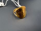 une bague en or posée sur une table, à côté d'une souris d'ordinateur