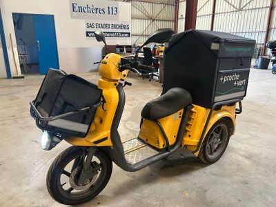 un scooter jaune avec un coffre noir à l'arrière
