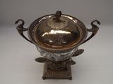 an antique silver plated bowl with ornate handles and a lid