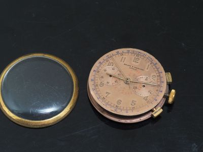 a pocket watch and a magnifying glass on a table