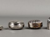 trois objets en argent posés les uns à côté des autres sur une table