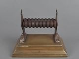 an antique brass plate with a wooden base and a wooden handle