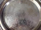 a silver plate with a silver handle on a table