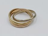 three gold and silver rings sitting on top of a white surface