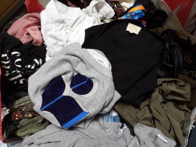 une valise rouge remplie de vêtements et d'une paire de chaussures