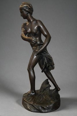 bronze statue of a woman holding a baby on a rock