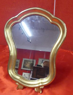 a mirror that is sitting on a red cloth