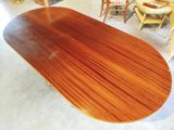 a wooden table with chairs around it in a room
