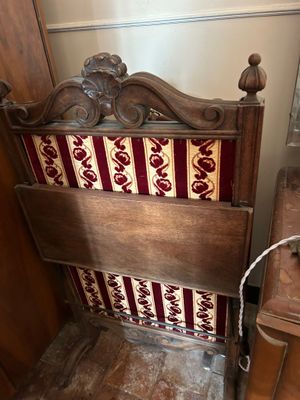 un lit en bois recouvert d'une couverture rouge et blanche