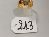 une petite bague en or surmontée d'une petite pièce en or