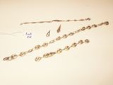two pieces of silver chain and a pair of scissors on a table