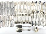 a lot of silver spoons and spoons on the table