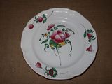 une assiette blanche ornée de fleurs roses, posée sur une table
