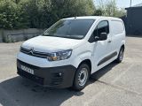 Une camionnette Citroën garée sur un parking, avec des arbres en arrière-plan