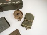 a green box with a belt and other items on a table
